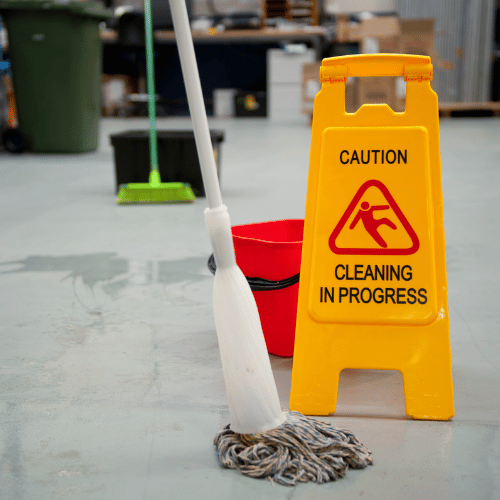 Znak „Cleaning in progress” przy mokrej podłodze – mop i wiadro podczas sprzątania magazynu _ hali produkcyjne
