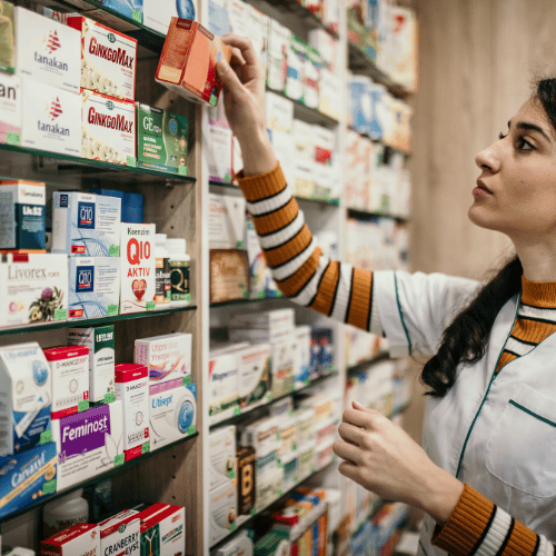 Farmaceutka układa leki na półce w aptece – czystość i porządek w aptece Lublin