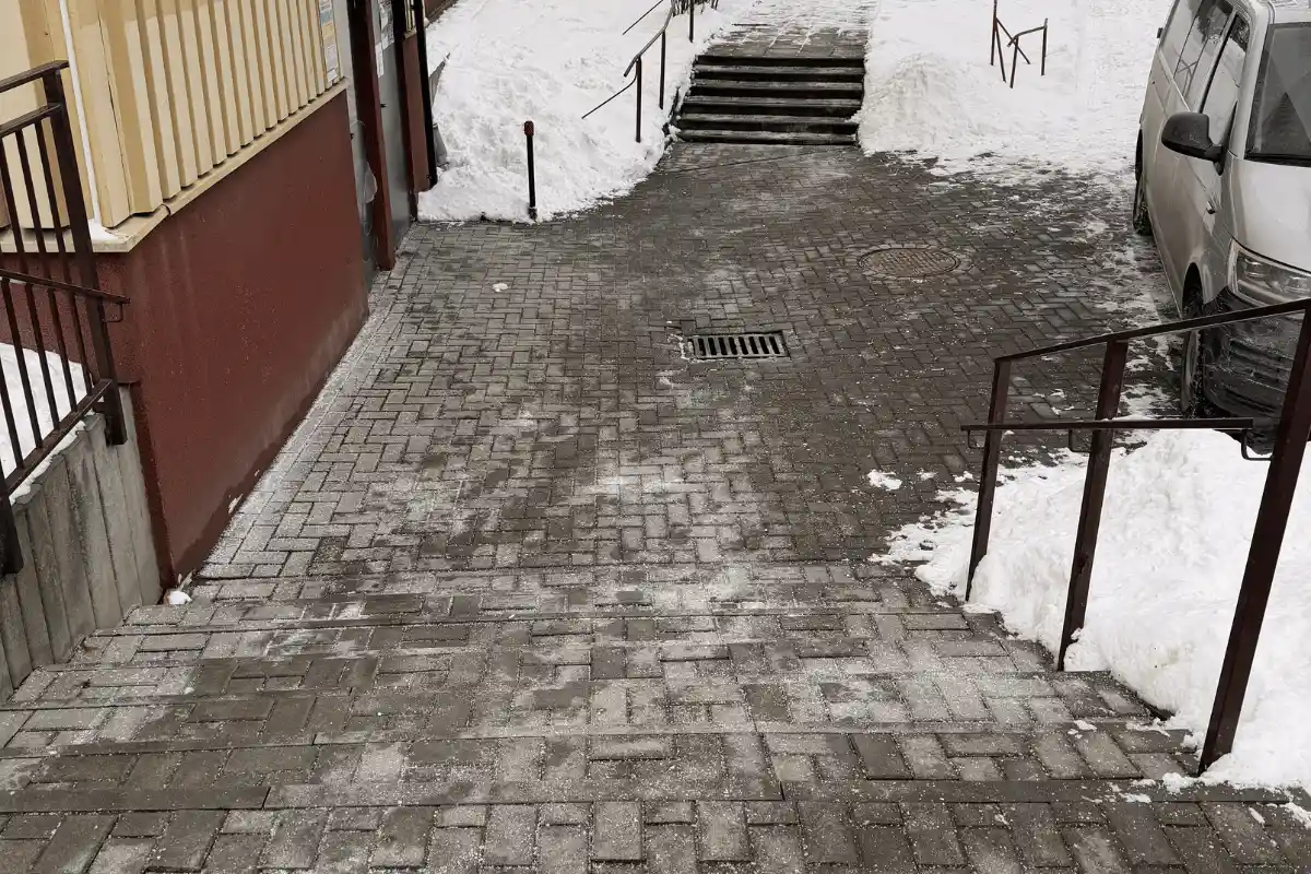 Odśnieżone wejście i chodnik przy budynku po zimowym utrzymaniu w Lublinie