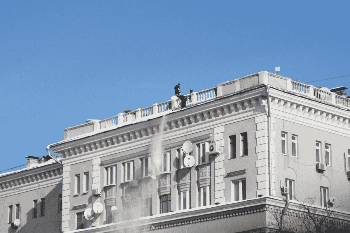 Bezpieczne usuwanie śniegu z płaskiego dachu budynku wielorodzinnego