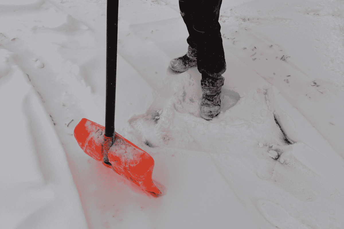 Ręczne odśnieżanie wąskiego przejścia na osiedlu w ramach całorocznej obsługi terenu