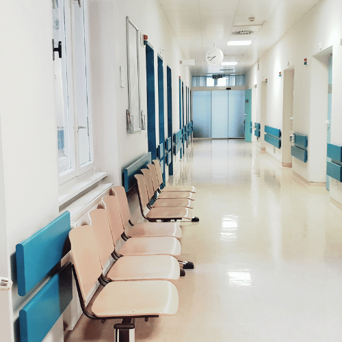 Korytarz przychodni z miejscami siedzącymi dla pacjentów – zadbane części wspólne