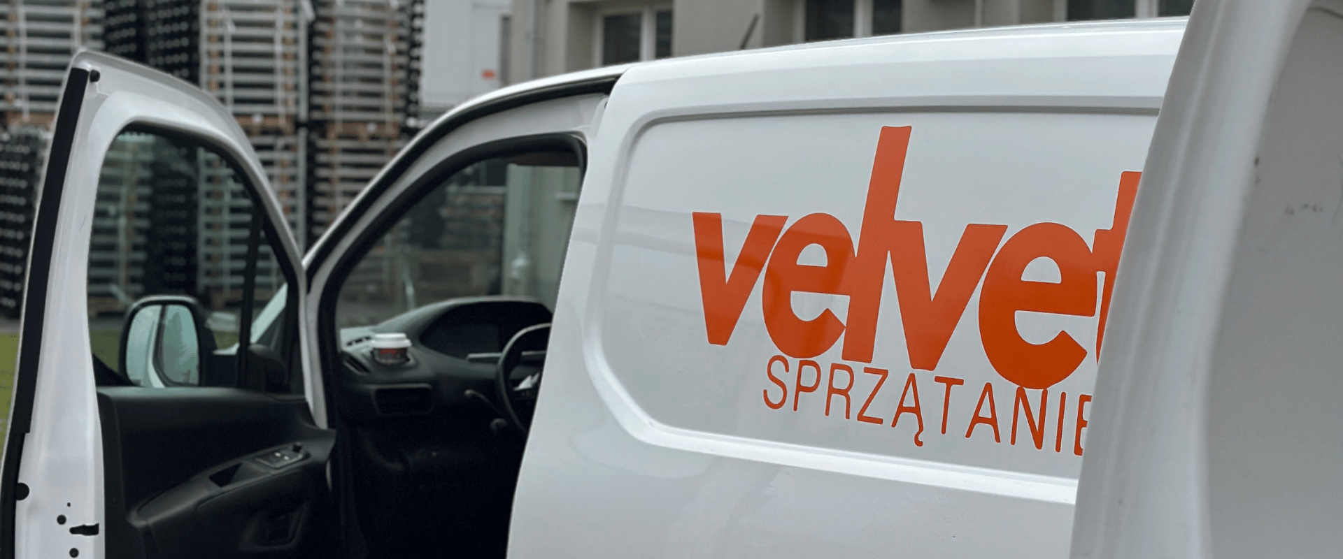 Samochód firmowy Velvet Sprzątanie z widocznym logo na boku i otwartymi drzwiami