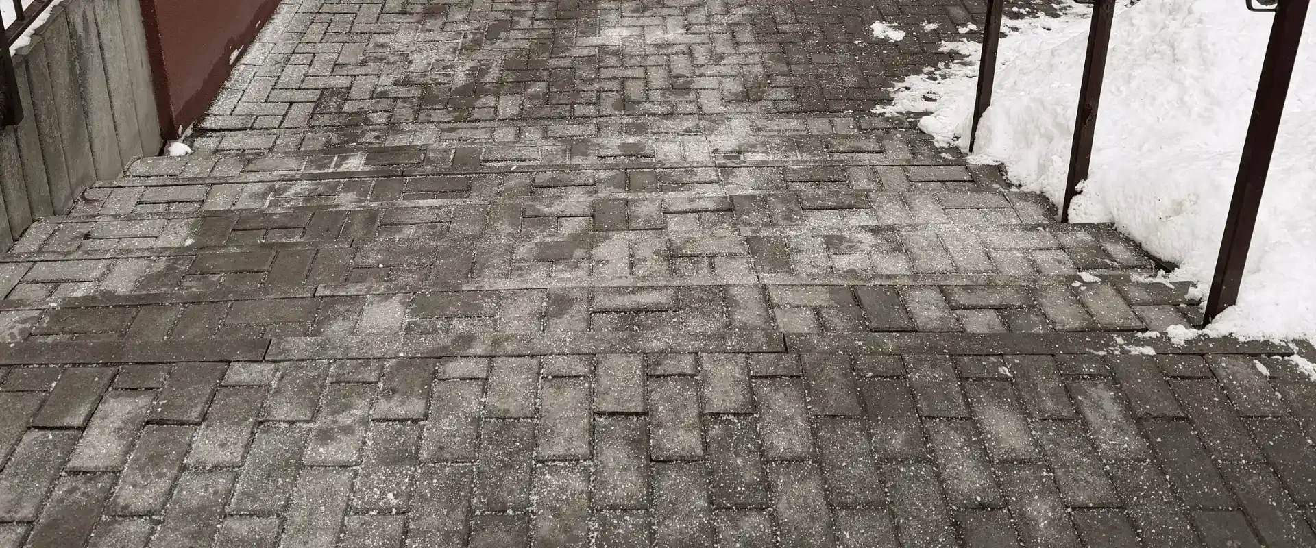 Usuwanie oblodzenia z chodnika przy budynku w Lublinie