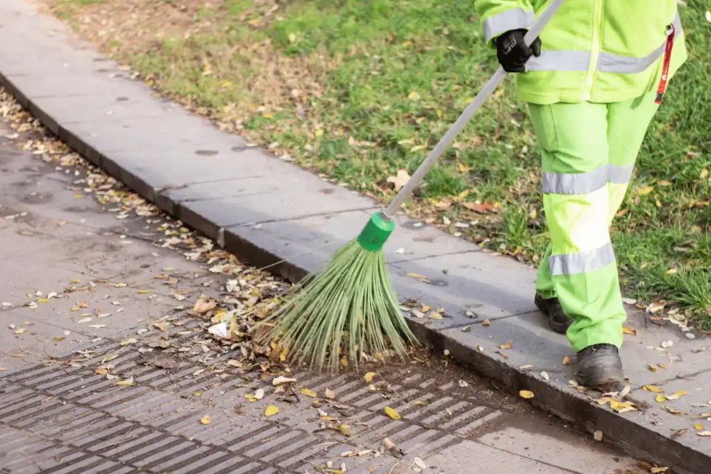 Usuwanie liści i zabrudzeń z krawężnika przy drodze wewnętrznej