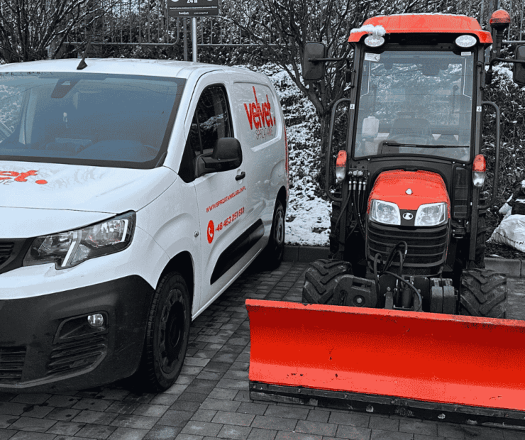 Sprzęt do zimowego utrzymania osiedla i samochód serwisowy podczas odśnieżania parkingu