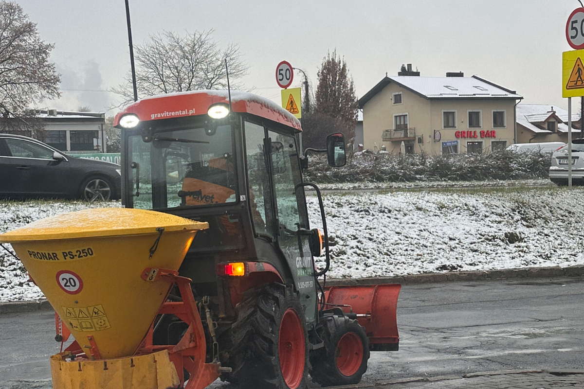 Zimowe utrzymanie terenu w Lublinie – traktor z pługiem i posypywarką naśnieżaodśnieża drogę wewnętrzną