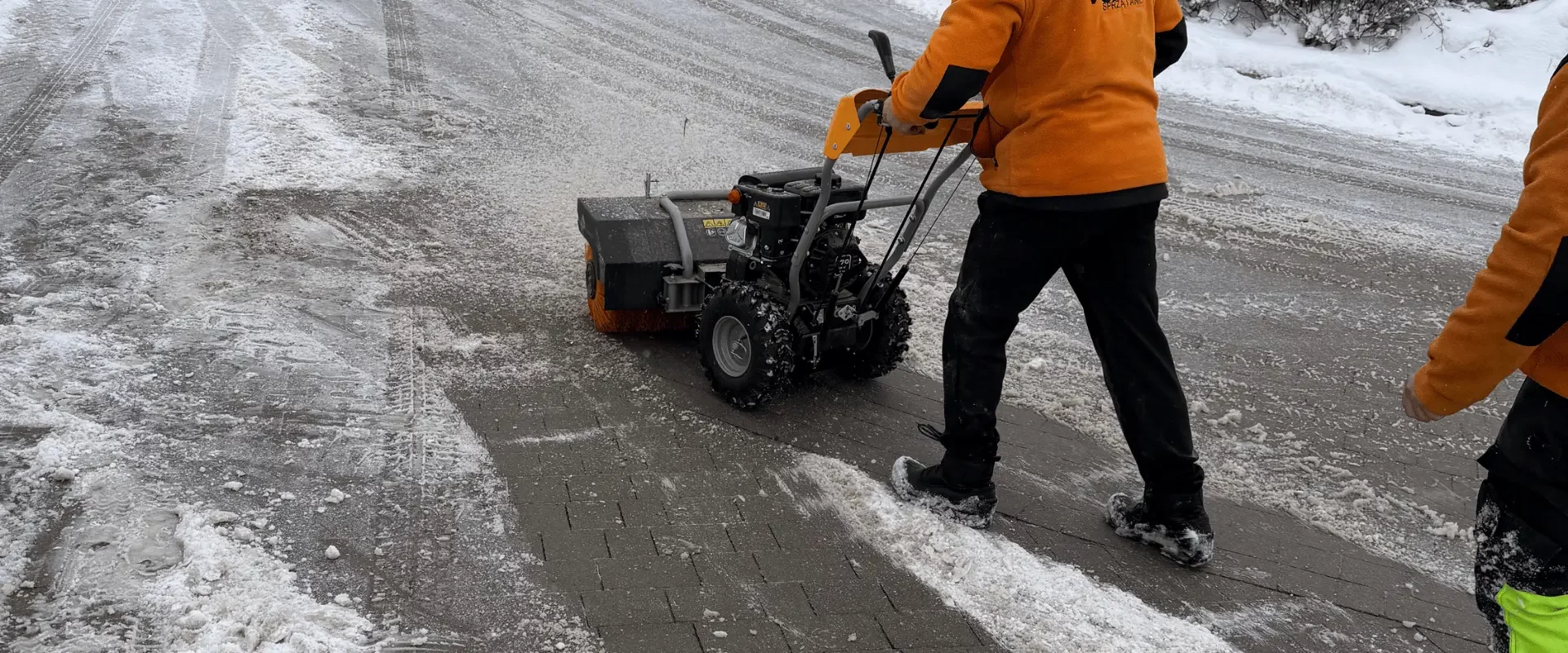 Mechaniczne odśnieżanie chodnika i drogi osiedlowej przy użyciu zamiatarki do śniegu