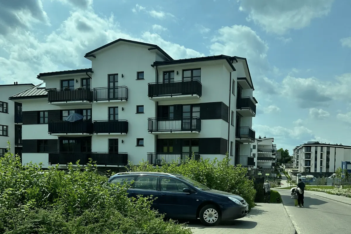Nowoczesny budynek mieszkalny z zadbanym otoczeniem, zielenią i drogą wewnętrzną na osiedlu