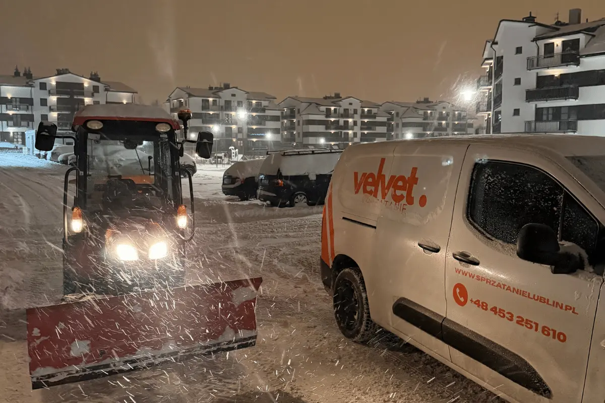 Odśnieżanie osiedla nocą z użyciem ciągnika z pługiem i auta Velvet Sprzątanie