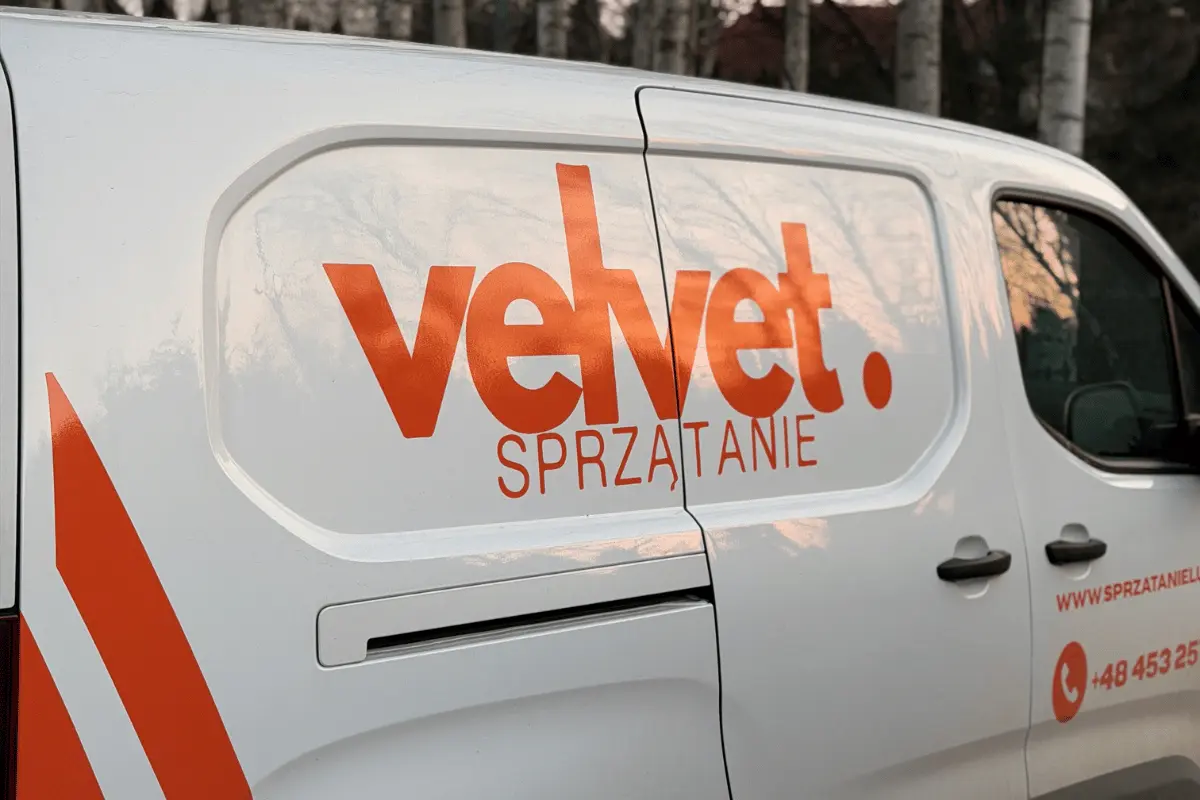 Oznakowany samochód Velvet Sprzątanie podczas realizacji usług utrzymania terenów zewnętrznych