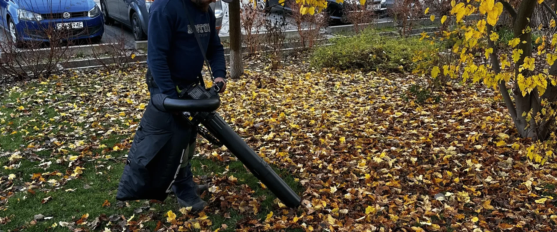 Usuwanie jesiennych liści dmuchawą na terenie osiedla mieszkaniowego