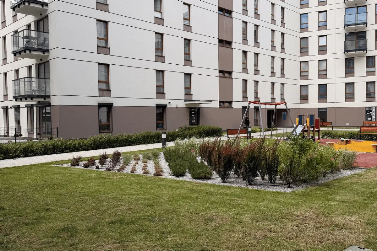Zadbany teren osiedla z placem zabaw i elementami małej architektury wspólnej