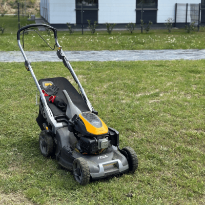 Kosiarka spalinowa na trawniku przy bloku – pielęgnacja zieleni osiedla