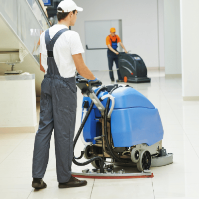 Maszynowe mycie posadzek – ekipa sprzątająca pracuje szorowarkami na dużej hali